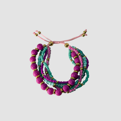 A multi-strand beaded bracelet set featuring pink and teal beads with gold spacer beads, displayed on a neutral gray background.